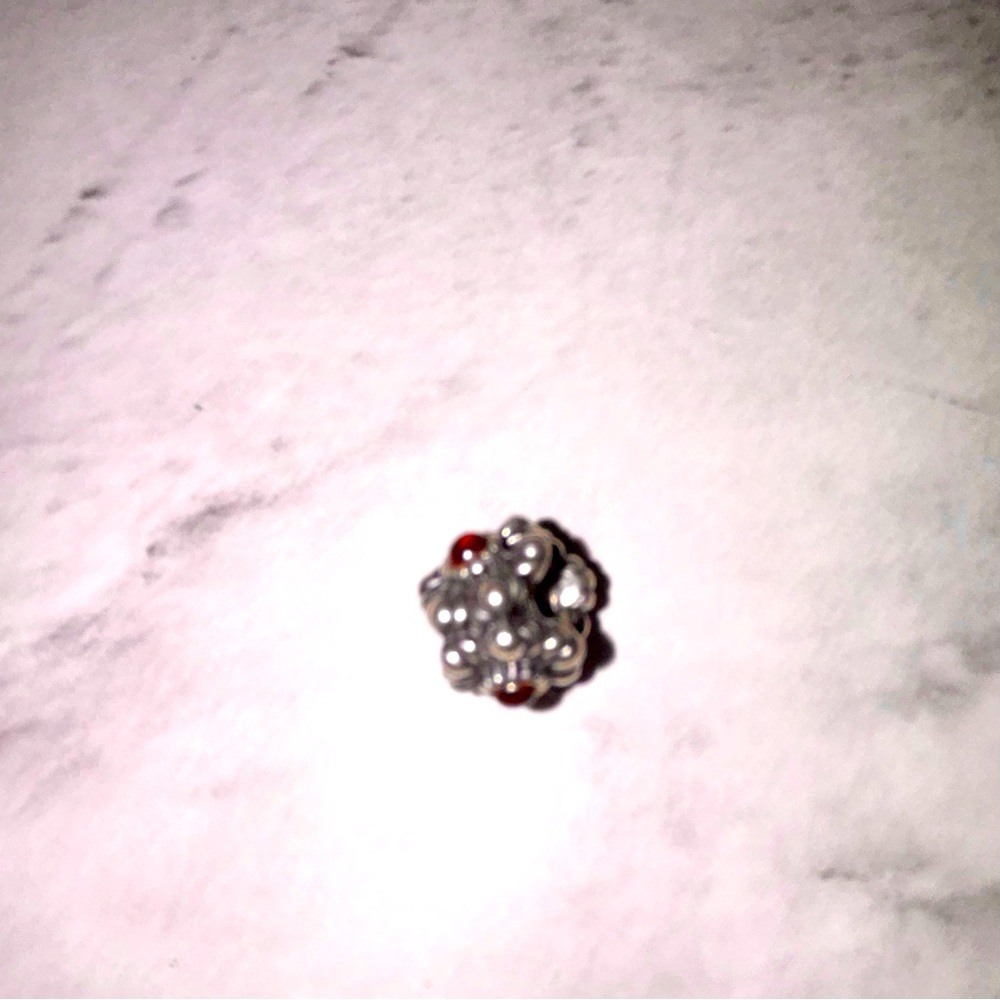 Pandora charm with deep red gem. Floral pattern around